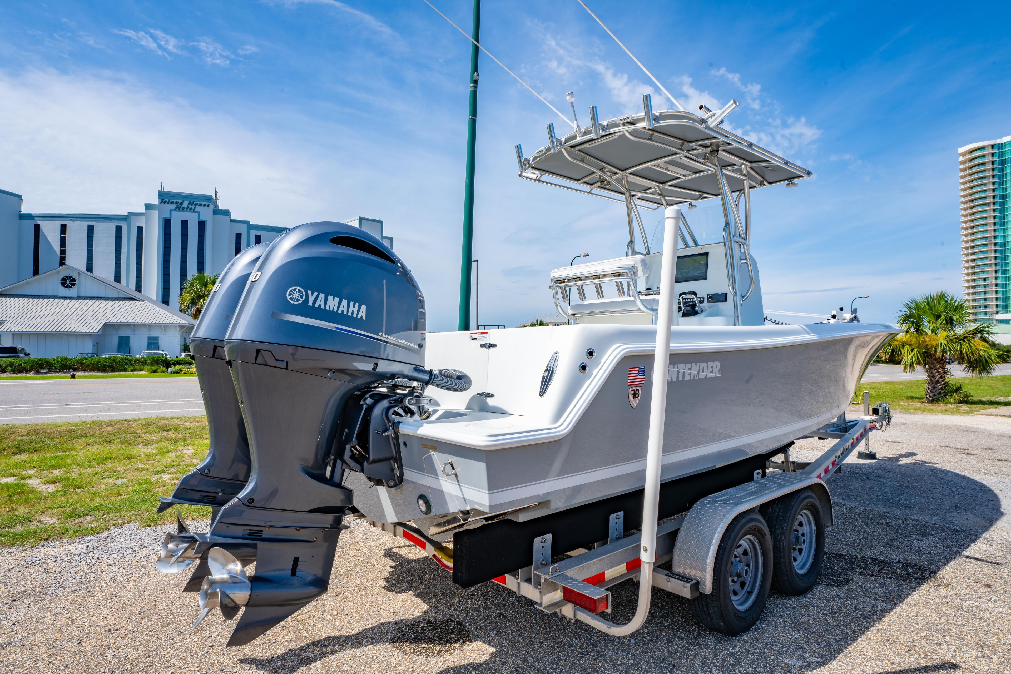 2022 Contender 25T boat with Yamaha engine on trailer, parked near buildings.