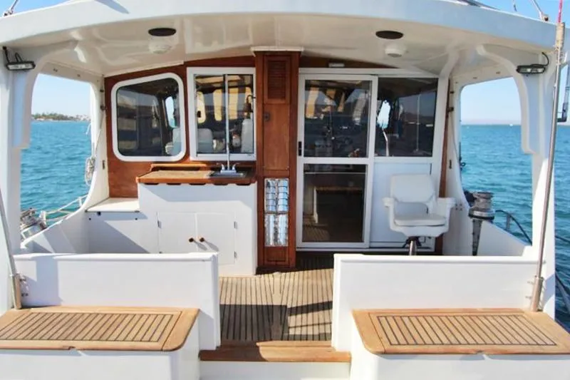  Yacht Photos Pics Centre cockpit pilot house of a 1991 custom steel cutter motorsailer, featuring wooden accents.