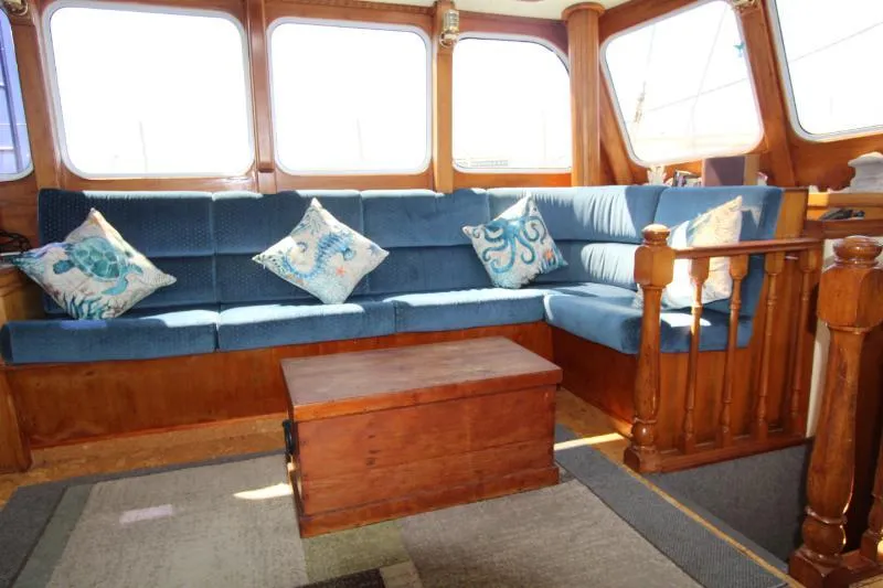  Yacht Photos Pics Luxurious interior of a 1991 Custom Centre Cockpit Pilot House Motorsailer with blue seating and wooden accents.