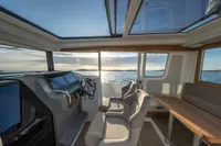 Luxurious 2023 Nimbus C9 boat interior with panoramic windows and modern seating, overlooking serene waters.