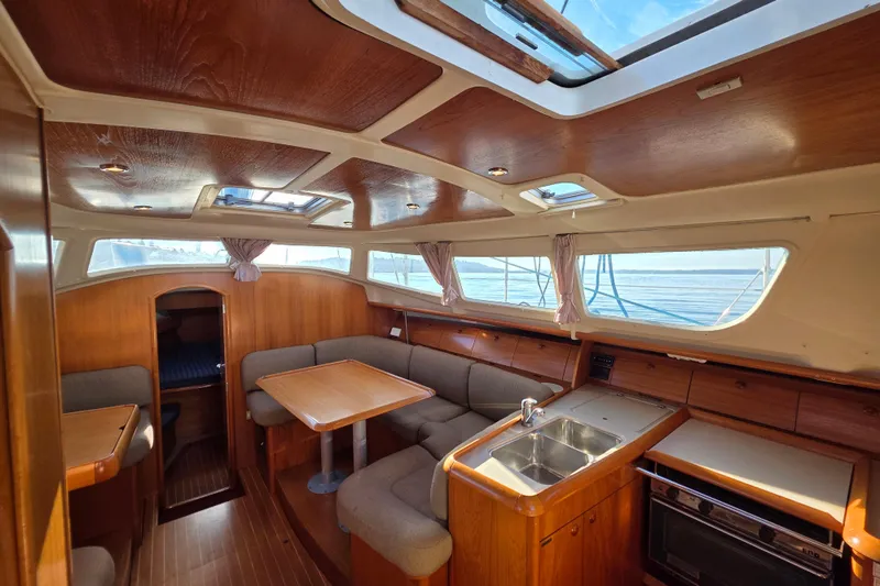 Hayabusa Yacht Photos Pics Interior of 1999 Jeanneau Sun Odyssey 40 DS sailboat with wood finish and seating area.