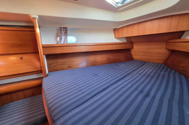 Hayabusa Yacht Photos Pics Cozy cabin interior of 1999 Jeanneau Sun Odyssey 40 DS with striped bedding.