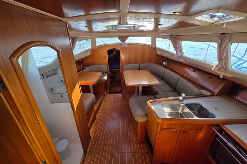 Hayabusa Yacht Photos Pics Interior of 1999 Jeanneau Sun Odyssey 40 DS sailboat, featuring wood finishes and cozy seating.