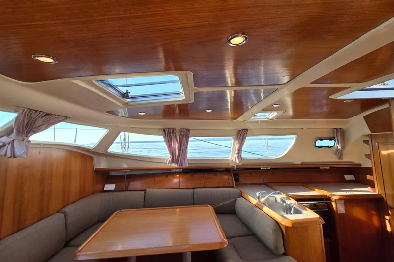 Hayabusa Yacht Photos Pics Interior of 1999 Jeanneau Sun Odyssey 40 DS sailboat with wood finish and seating area.
