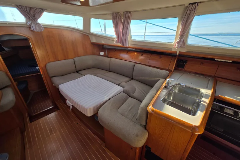 Hayabusa Yacht Photos Pics Interior of 1999 Jeanneau Sun Odyssey 40 DS sailboat with cozy seating and kitchenette.