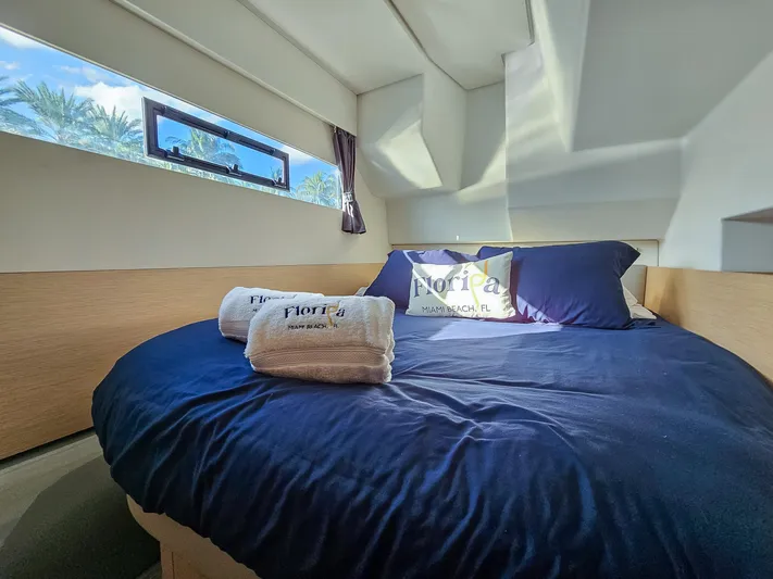 Floripa Yacht Photos Pics Cozy bedroom in 2017 Fountaine Pajot MY 37 yacht with blue bedding and window view.