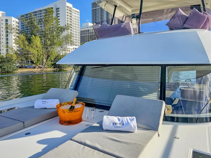 Floripa Yacht Photos Pics Luxurious 2017 Fountaine Pajot MY 37 yacht with sunbathing area and champagne, docked near cityscape.