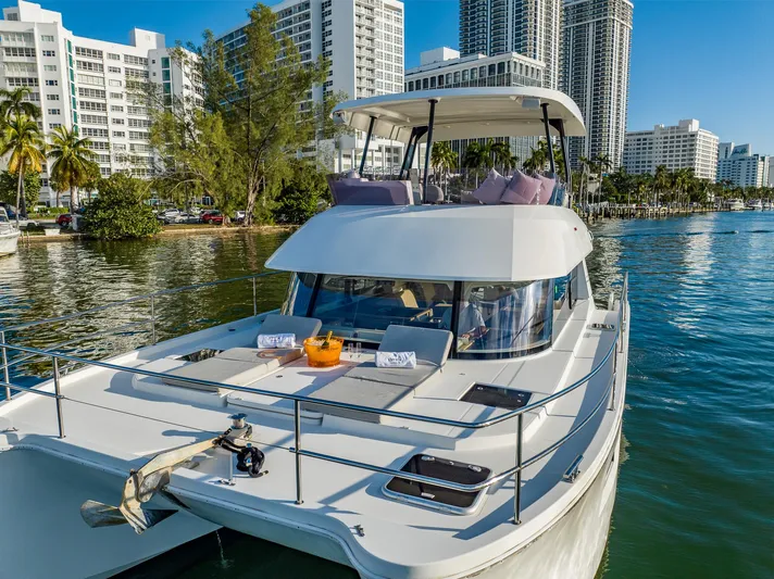 Floripa Yacht Photos Pics 2017 Fountaine Pajot MY 37 yacht cruising near urban waterfront with modern buildings.