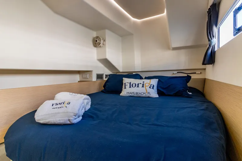 Floripa Yacht Photos Pics Cozy cabin interior of 2017 Fountaine Pajot MY 37 with navy bedding and Florida-themed decor.