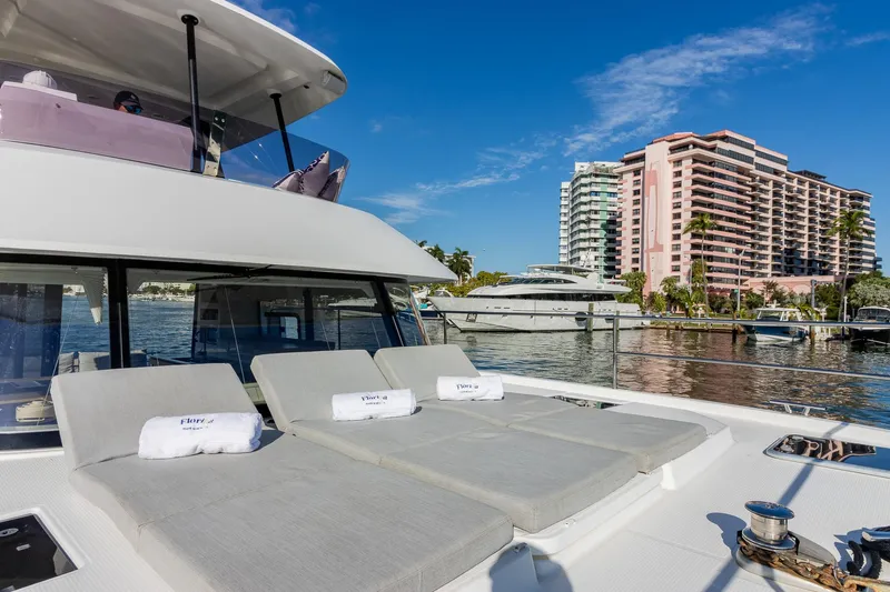 Floripa Yacht Photos Pics Luxury Fountaine Pajot MY 37 yacht with sun loungers, docked near waterfront buildings.
