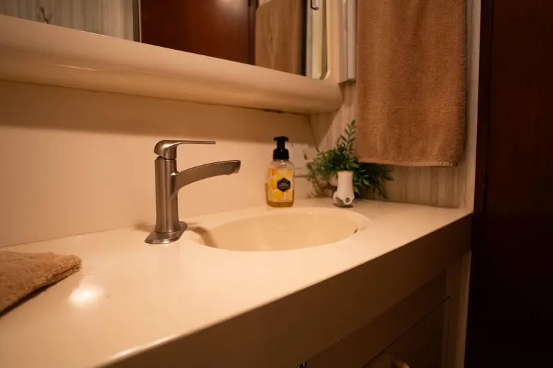 Bloodline Yacht Photos Pics Bathroom sink area on 1990 Hatteras 58 Convertible yacht, featuring modern faucet and decor.