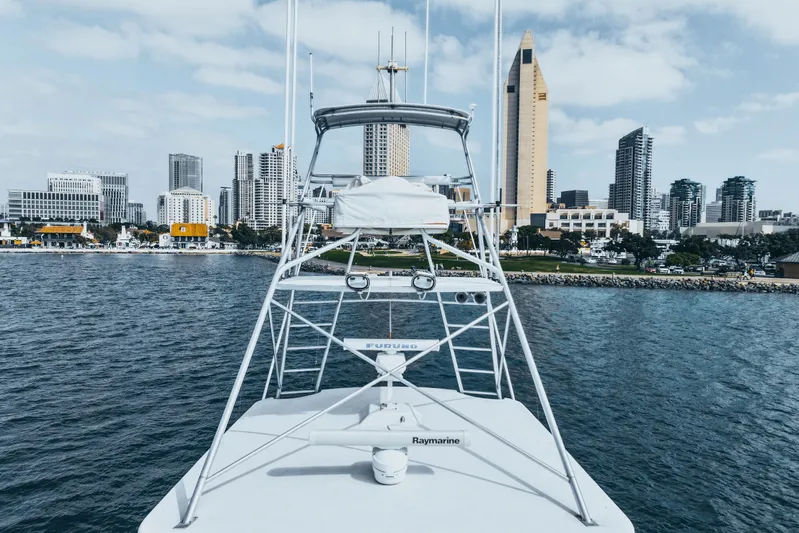 Bloodline Yacht Photos Pics 1990 Hatteras 58 Convertible yacht with city skyline in the background.