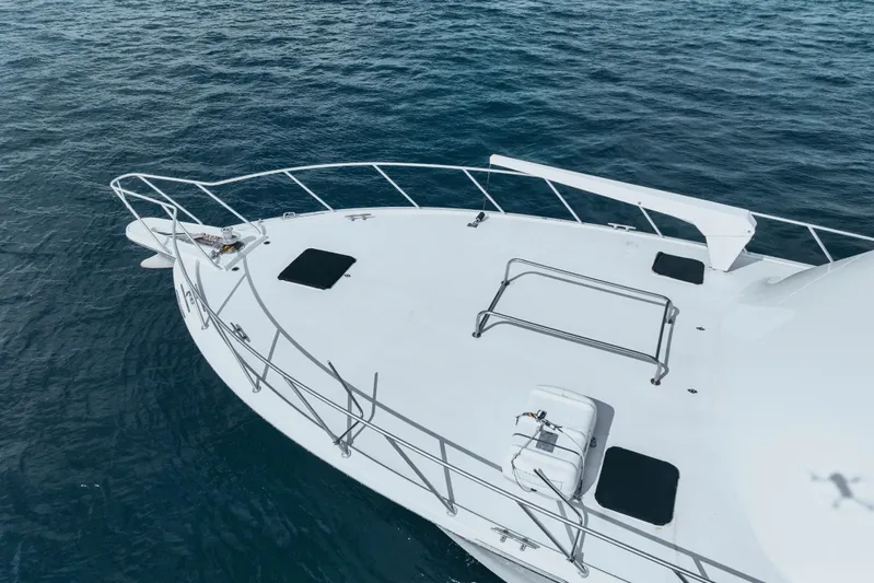 Bloodline Yacht Photos Pics Bow of 1990 Hatteras 58 Convertible yacht on calm blue water.