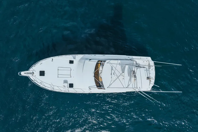 Bloodline Yacht Photos Pics Aerial view of 1990 Hatteras 58 Convertible yacht on blue ocean water.