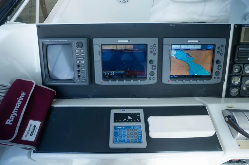 Bloodline Yacht Photos Pics Control panel of a 1990 Hatteras 58 Convertible with navigation screens and Raymarine equipment.