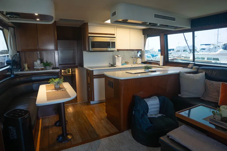 Bloodline Yacht Photos Pics Luxurious interior of a 1990 Hatteras 58 Convertible yacht with modern kitchen and seating area.