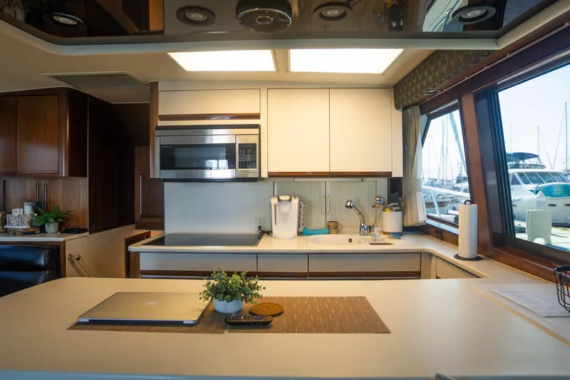 Bloodline Yacht Photos Pics Modern kitchen interior on a 1990 Hatteras 58 Convertible yacht with marina view.