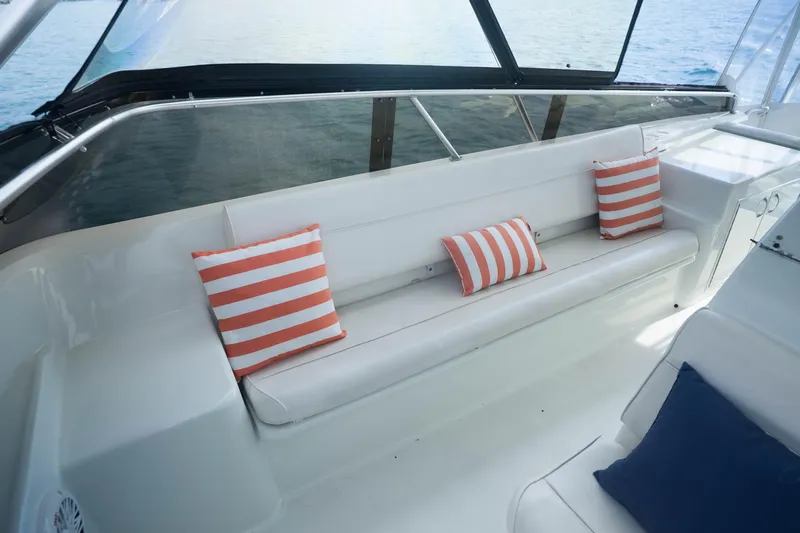 Bloodline Yacht Photos Pics 1990 Hatteras 58 Convertible yacht interior with striped cushions on white seating.
