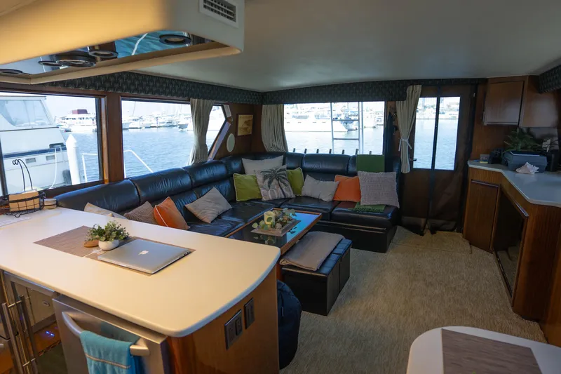Bloodline Yacht Photos Pics Luxurious interior of 1990 Hatteras 58 Convertible yacht with spacious seating and marina view.