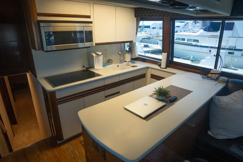 Bloodline Yacht Photos Pics Modern kitchen interior on a 1990 Hatteras 58 Convertible yacht with large windows.