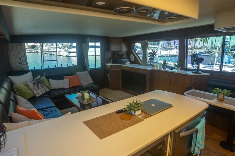 Bloodline Yacht Photos Pics Luxurious interior of 1990 Hatteras 58 Convertible yacht with marina view.