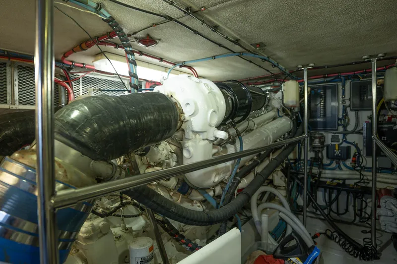 Bloodline Yacht Photos Pics Engine room of a 1990 Hatteras 58 Convertible yacht, showcasing complex machinery and wiring.