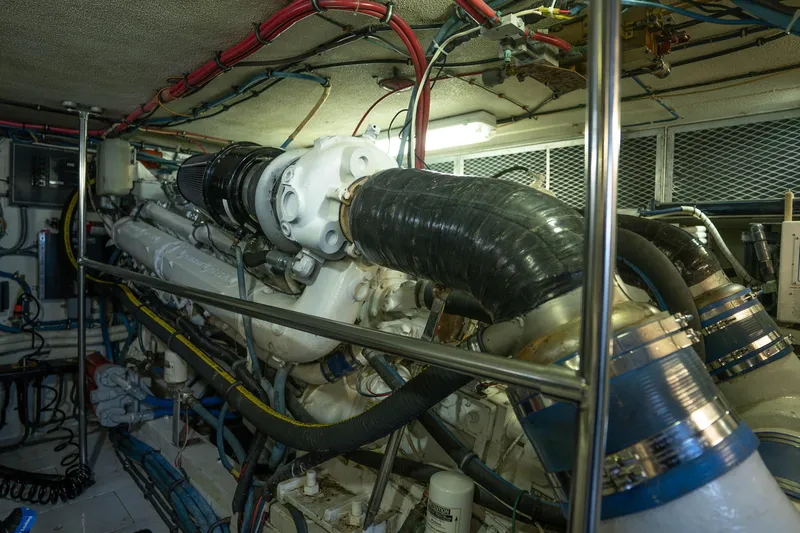 Bloodline Yacht Photos Pics Engine room of 1990 Hatteras 58 Convertible yacht, showcasing complex machinery and wiring.