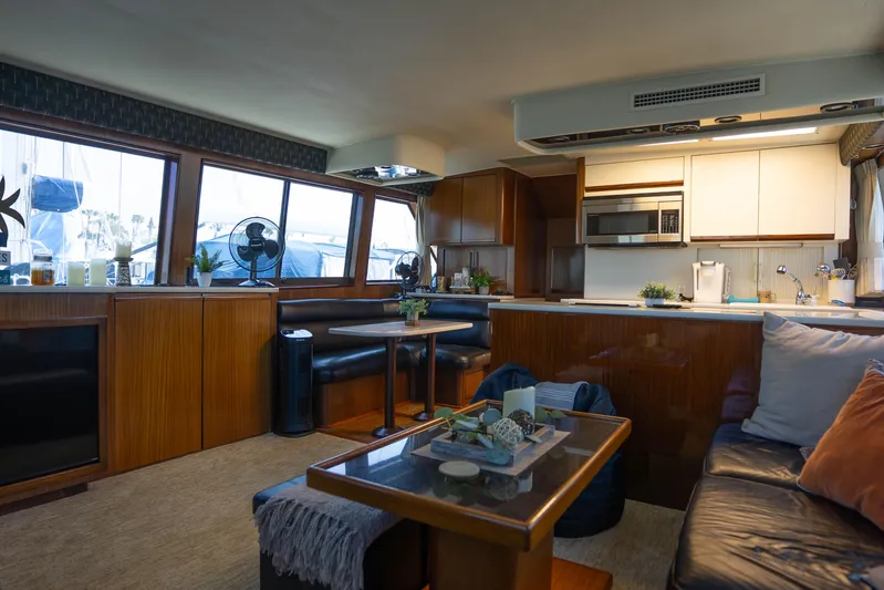 Bloodline Yacht Photos Pics Luxurious interior of 1990 Hatteras 58 Convertible yacht with modern kitchen and seating area.