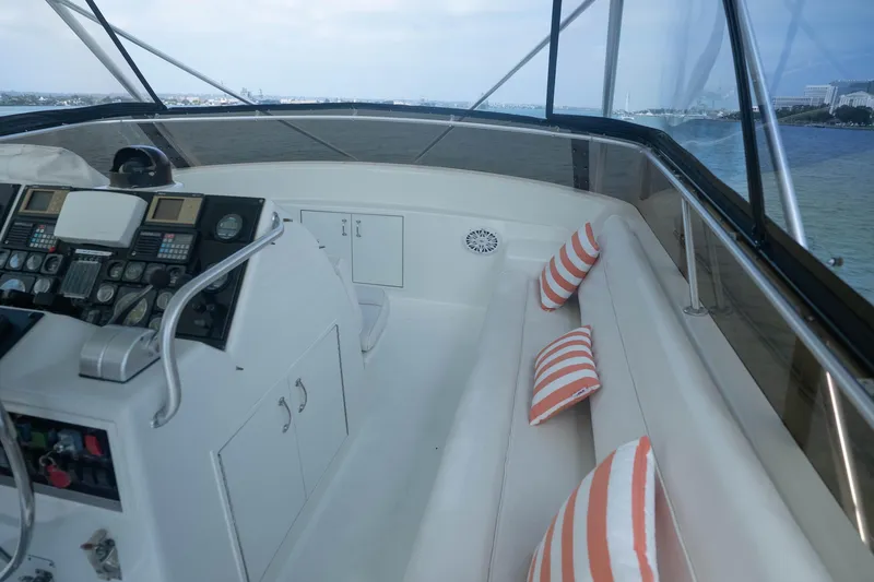 Bloodline Yacht Photos Pics 1990 Hatteras 58 Convertible yacht helm with striped cushions and panoramic view.