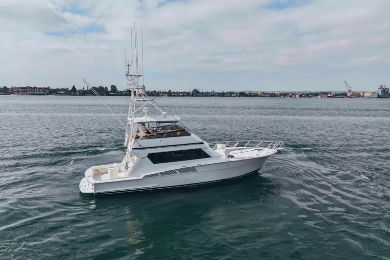 Bloodline Yacht Photos Pics 1990 Hatteras 58 Convertible yacht cruising on open water under a cloudy sky.
