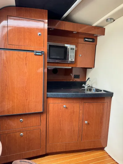  Yacht Photos Pics 2006 Regal Commodore 3560 IO yacht kitchen with wood cabinets, microwave, and sink.