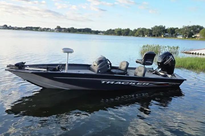 2020 Tracker Pro Team 175 TF boat on a serene lake under a blue sky.