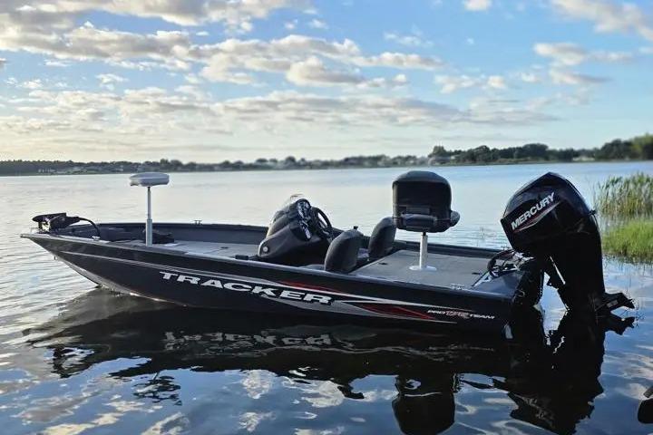 2020 Tracker Pro Team 175 TF boat on a serene lake under a cloudy sky.