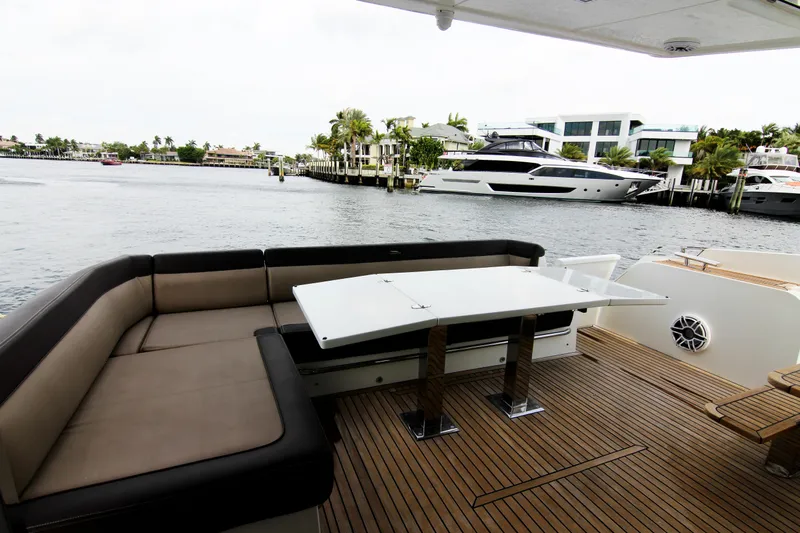 Bugsy Yacht Photos Pics Luxury Galeon 550 Fly yacht deck with seating and table, 2020 model, docked by waterfront homes.