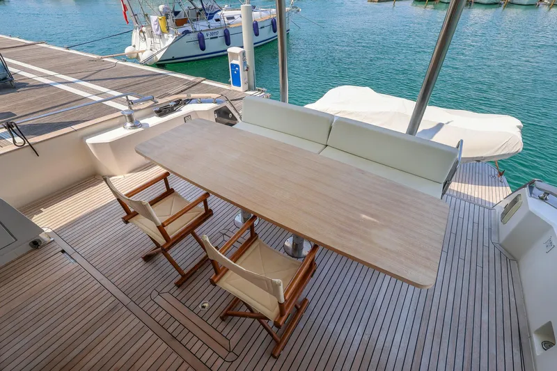 Mas Que Nada Yacht Photos Pics Outdoor dining area on 2021 Greenline OceanClass 68 yacht with wooden table and chairs.