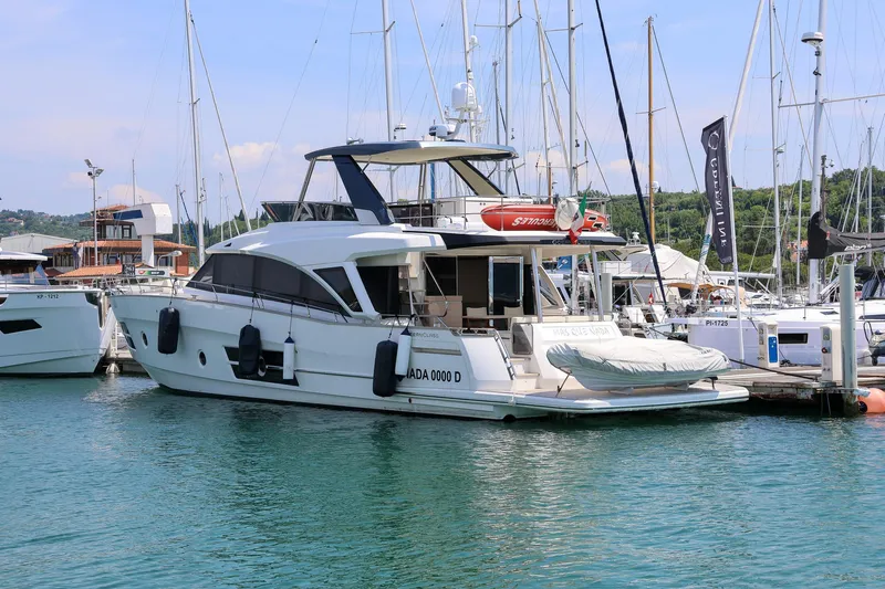Mas Que Nada Yacht Photos Pics 2021 Greenline OceanClass 68 yacht docked in a marina, surrounded by other boats.