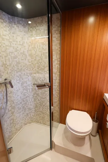 Mas Que Nada Yacht Photos Pics Luxurious bathroom in 2021 Greenline OceanClass 68 yacht with wood paneling and glass shower.
