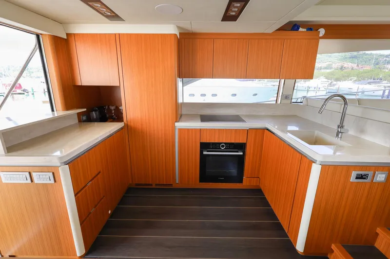Mas Que Nada Yacht Photos Pics Modern kitchen interior on 2021 Greenline OceanClass 68 yacht, featuring sleek wood cabinetry.