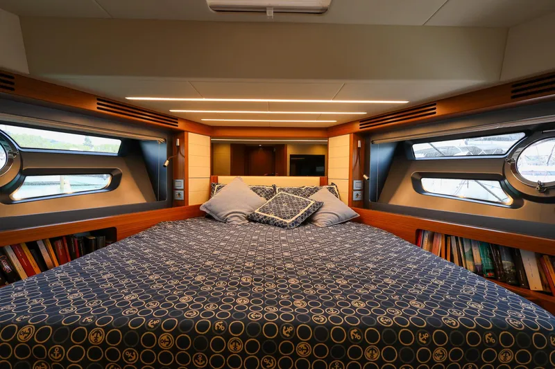Mas Que Nada Yacht Photos Pics Luxurious cabin interior of 2021 Greenline OceanClass 68 yacht with cozy bedding and porthole windows.