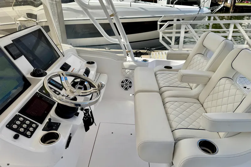  Yacht Photos Pics 2022 Intrepid 409 Valor helm with dual seats, steering wheel, and navigation screens.