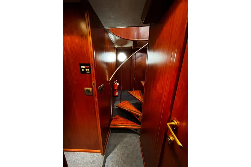 Alieva Yacht Photos Pics Interior of 2010 Joubert-Nivelt ALIEVA 60 yacht with wooden staircase and fire extinguisher.