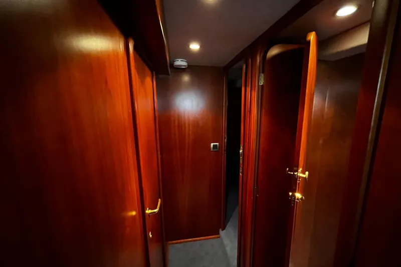 Alieva Yacht Photos Pics Wood-paneled hallway inside 2010 Joubert-Nivelt ALIEVA 60 yacht, featuring elegant doors and lighting.