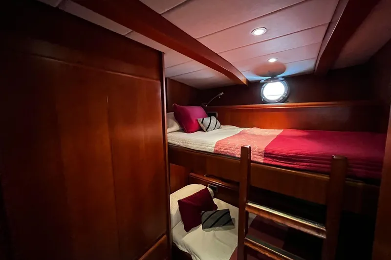 Alieva Yacht Photos Pics Cozy cabin interior of 2010 Joubert-Nivelt ALIEVA 60 yacht with wooden finish and porthole.