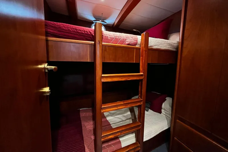 Alieva Yacht Photos Pics Bunk beds in 2010 Joubert-Nivelt ALIEVA 60 yacht cabin, featuring wooden ladder and cozy bedding.