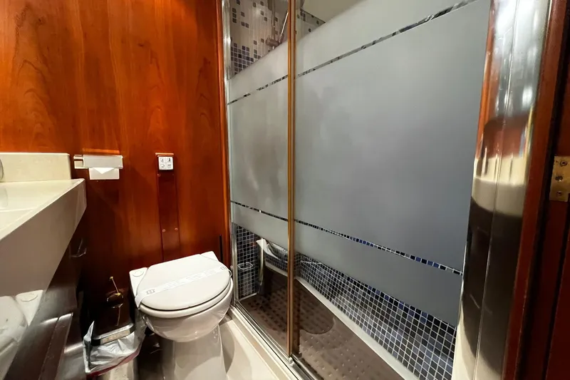 Alieva Yacht Photos Pics Bathroom interior of 2010 Joubert-Nivelt ALIEVA 60 yacht with wooden paneling and frosted glass shower.