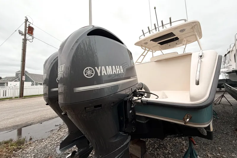  Yacht Photos Pics 2014 Pursuit S 280 Sport boat with Yamaha outboard engines, parked on gravel.