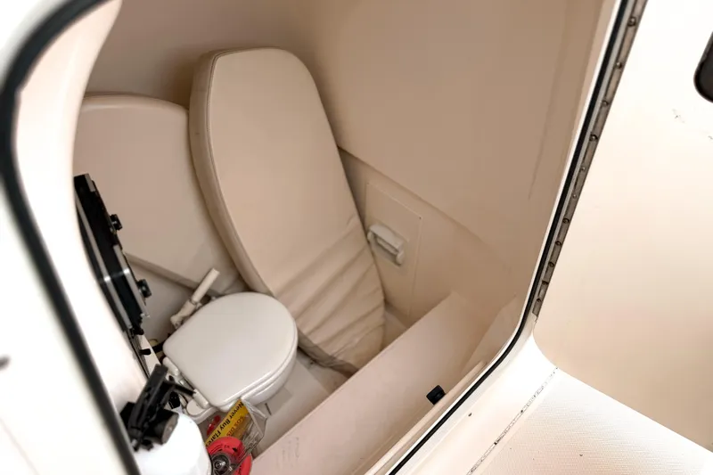  Yacht Photos Pics 2014 Pursuit S 280 Sport boat interior with compact toilet and seating area.