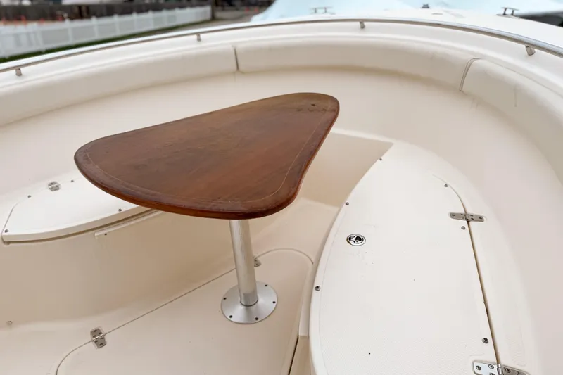  Yacht Photos Pics 2014 Pursuit S 280 Sport boat interior with wooden table and white seating.