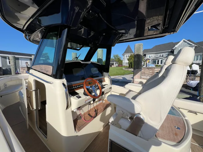 Sea Senora Yacht Photos Pics 2022 Chris-Craft Catalina 30 helm station with captain's chair and wooden steering wheel.