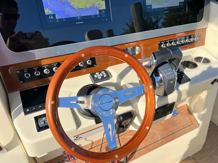 Sea Senora Yacht Photos Pics 2022 Chris-Craft Catalina 30 helm with wooden steering wheel and modern navigation system.